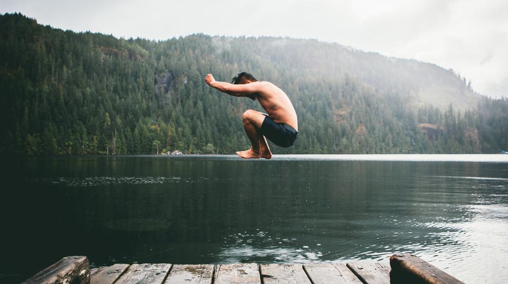 Mann hüpft in einen See