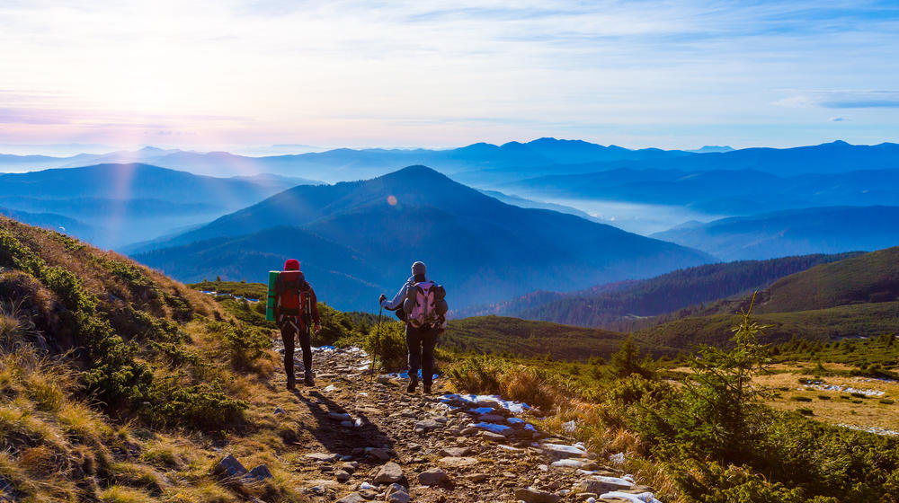 Zwei Wanderer mit Aussicht von einem Hochplateau