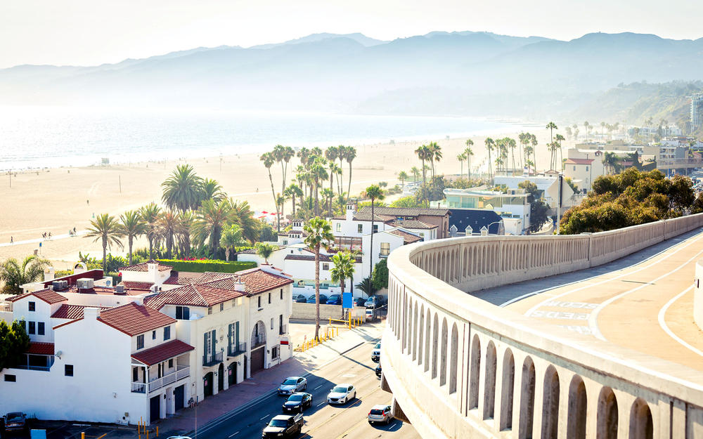Kalifornische Küstenstraße mit Strandhäusern und dem Meer im Hintergrund.