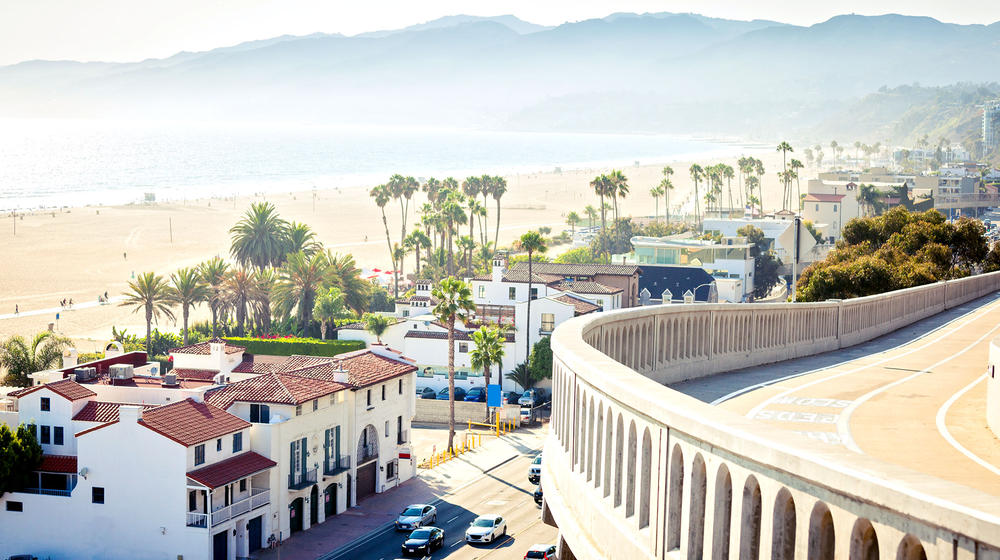 Kalifornische Küstenstraße mit Strandhäusern und dem Meer im Hintergrund.