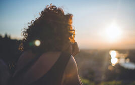 Rear view of a young woman wearing sunglasses in the evening sun