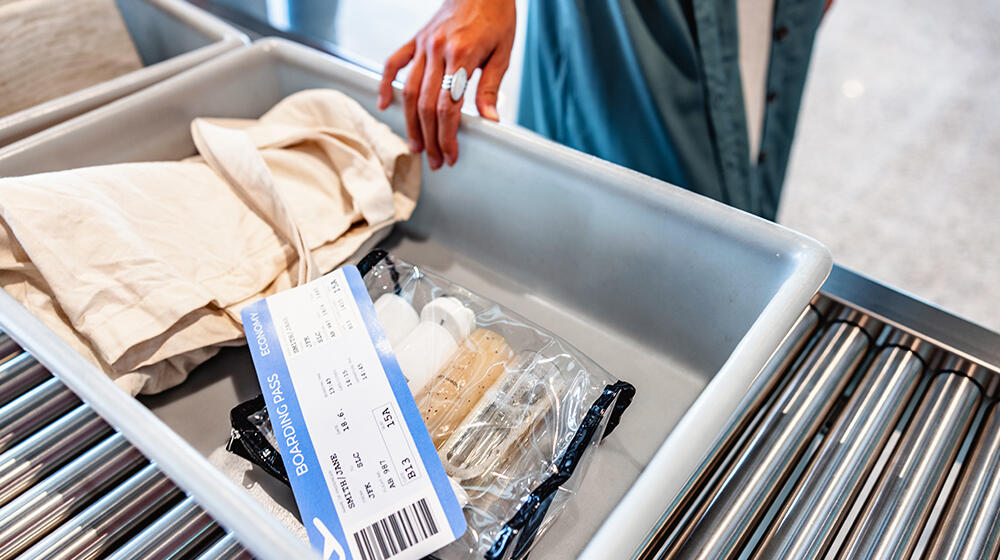 Traveler displays luggage contents and boarding pass at the security checkpoint
