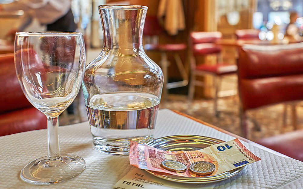 Bargeld inklusive Trinkgeld auf einem Rechnungsteller in einem Café