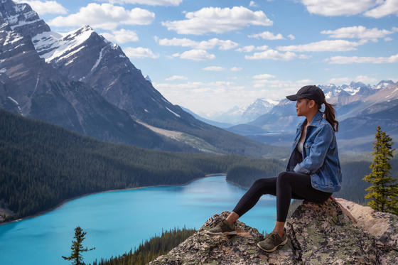 Young woman admires view of Canadian mountains and a lake