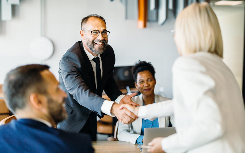 Meeting unter Geschäftsleuten, die sich freundlich die Hand zur Begrüßung reichen
