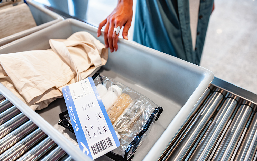 Traveler displays luggage contents and boarding pass at the security checkpoint